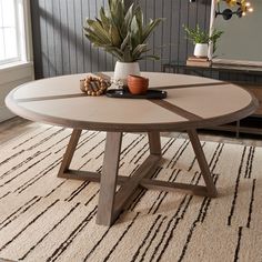 a living room with a round coffee table and potted plant