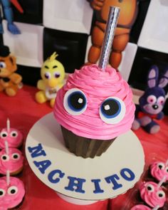 there is a cupcake with pink frosting and eyes on the top that says machito