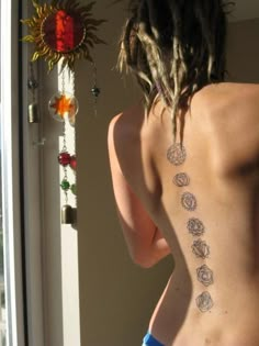 the back of a woman's body with tattoos on it