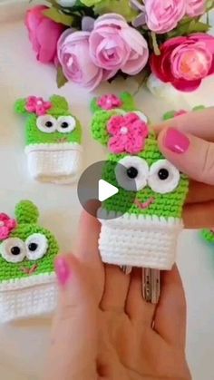 someone is holding up some tiny crocheted items to make them look like they're