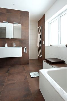 a modern bathroom with brown tile and white fixtures