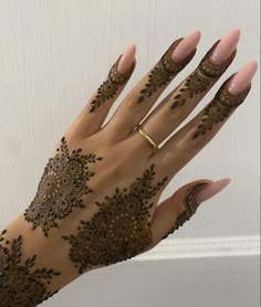 a woman's hand with henna tattoos on it