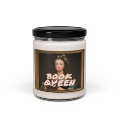 a white candle with the words book queen on it and an image of a woman's face