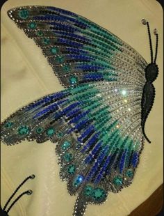 a blue and green butterfly made out of beads