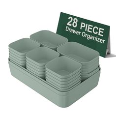 a set of twelve gray square dishes next to a sign that says 28 piece drawer organizer