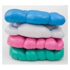 four different colored pillows stacked on top of each other in the shape of an animal's mouth