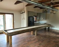 an empty kitchen and dining room with a pool table in the middle of the room