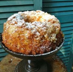 a cake sitting on top of a wooden table covered in powdered sugar and crumbs