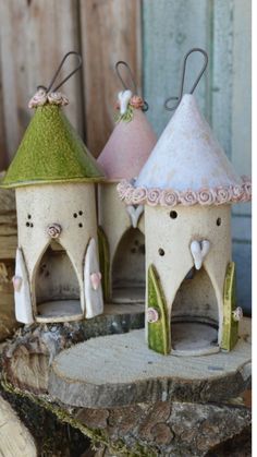 three little houses made out of clay sitting on top of a tree stump