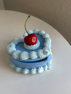 there is a small cake with a cherry on top