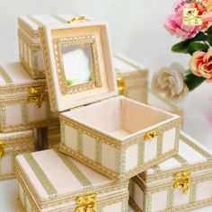 there are four small boxes with gold trimmings on the sides and one has a mirror in it