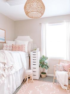 a bedroom with white bedding and pink accents