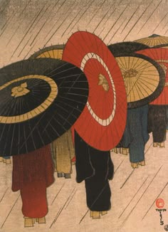 several people with umbrellas walking in the rain