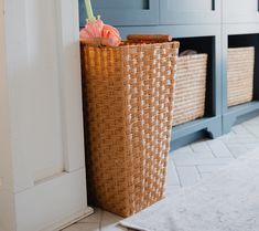 a wicker basket sitting on the floor next to a cabinet