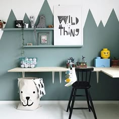 a room with mountains painted on the wall and two desks next to each other