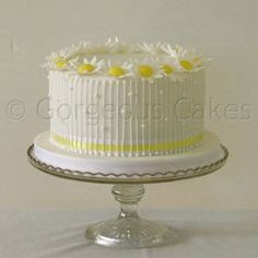 a white cake with yellow and white flowers on top