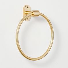 a gold towel ring on a white surface with a clip in the middle that is attached to it