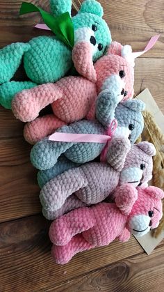 there are many crocheted stuffed animals in the pile together on the wooden floor