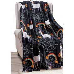 a black blanket sitting on top of a white chair next to a window with spider webs and rainbows