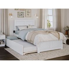 a white bed sitting on top of a wooden floor next to a dresser and window