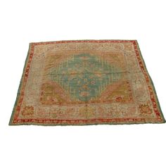 an antique persian rug is on display against a white background with red and green accents