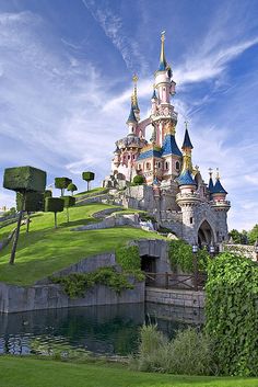 an image of a castle on top of a hill that is surrounded by greenery