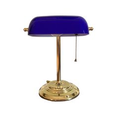 a blue lamp on a brass base with a chain hanging from it's end