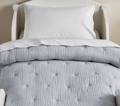 a bed with white pillows and blue bedspread