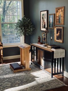 a living room with blue walls and pictures on the wall next to a wooden table