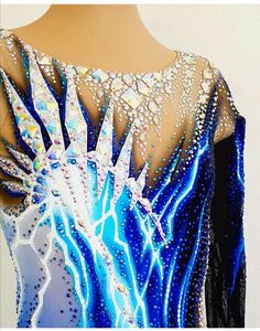 a woman's blue and white figure skating dress with crystals on the back,