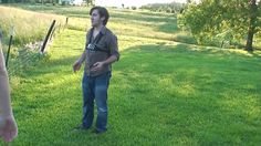 a man standing on top of a lush green field next to a woman holding a frisbee