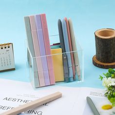 several office supplies are sitting on top of a desk next to a calendar and pen