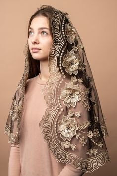 a woman wearing a veil with flowers and leaves on the side, in front of a brown background