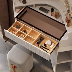 an open drawer on top of a white desk with various items in it and a stool next to it