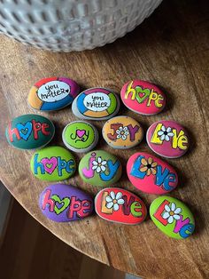 several decorated rocks sitting on top of a wooden table