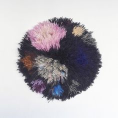 a multicolored round rug on a white background