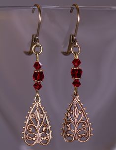 Delicate antiqued brass filigree earrings with red Czech Glass.  That are about 1 7/8 inches long Red Dangle Filigree Jewelry, Red Filigree Dangle Jewelry, Ornate Red Dangle Earrings, Ornate Red Filigree Earrings, Elegant Red Chandelier Earrings With Intricate Design, Red Filigree Dangle Earrings, Vintage Red Dangle Chandelier Earrings, Red Vintage Dangle Chandelier Earrings, Ornate Red Drop Earrings