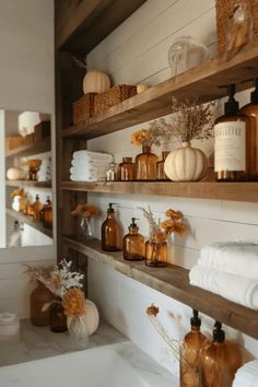 Rustic bathroom shelves decorated with brown glass bottles, white pumpkins, wicker baskets, and towels. Farmhouse Dinnerware Sets, Fall Bathroom Decor Ideas, Farmhouse Dinnerware, Fall Bathroom Decor, Barnwood Shelves, Shed Tiny House, Yard Sheds, Fall Bathroom, Easy Reference