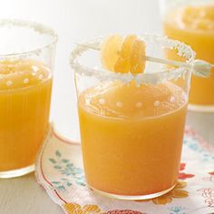 two glasses filled with orange juice on top of a table