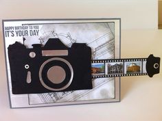 a birthday card with a camera and film strip attached to the back of it's frame