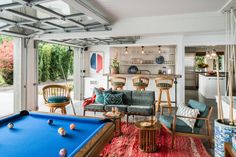 a pool table in the middle of a living room with lots of furniture and decor