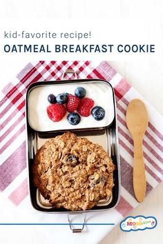 a container filled with granola, yogurt and berries next to a spoon