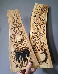 two wooden spoons with designs on them are being held in front of the camera