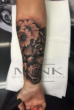 a black and white tiger with flowers on his leg