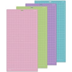 three different colored cutting mats on a white background, each with a grid pattern in the middle