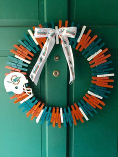 a wreath made out of toothpicks with a football helmet on the front door