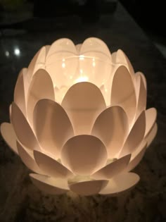 a lit up white flower sitting on top of a table