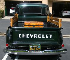 an old green chevrolet pickup truck parked in a parking lot