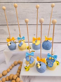 there are some cake pops with bees on them and blue candies in the background