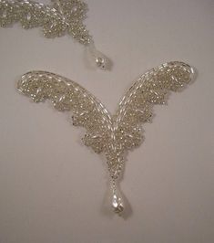 two silver necklaces on a white surface